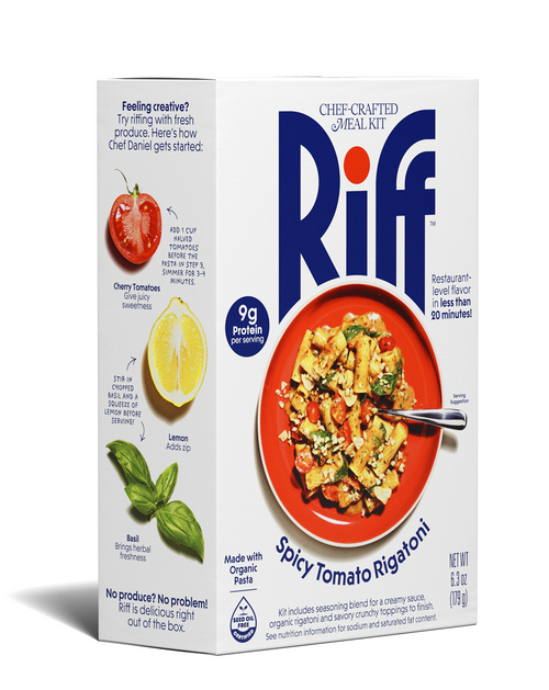 Front of a Riff Spicy Tomato Rigatoni chef-crafted meal kit box, featuring a red plate of rigatoni pasta with cherry tomatoes, greens, and crumbled topping, with a spoon resting in the dish.