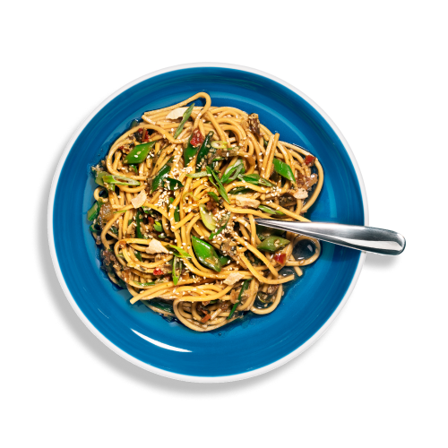 Overhead shot of a small bowl of Riff sesame ginger noodles with a fork.