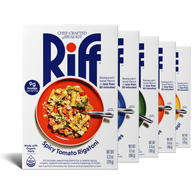 Five Riff chef-crafted meal kit boxes fanned out in a row, with a box of Spicy Tomato Rigatoni in front showing a red plate of pasta and partial views of the other four flavor boxes behind it.