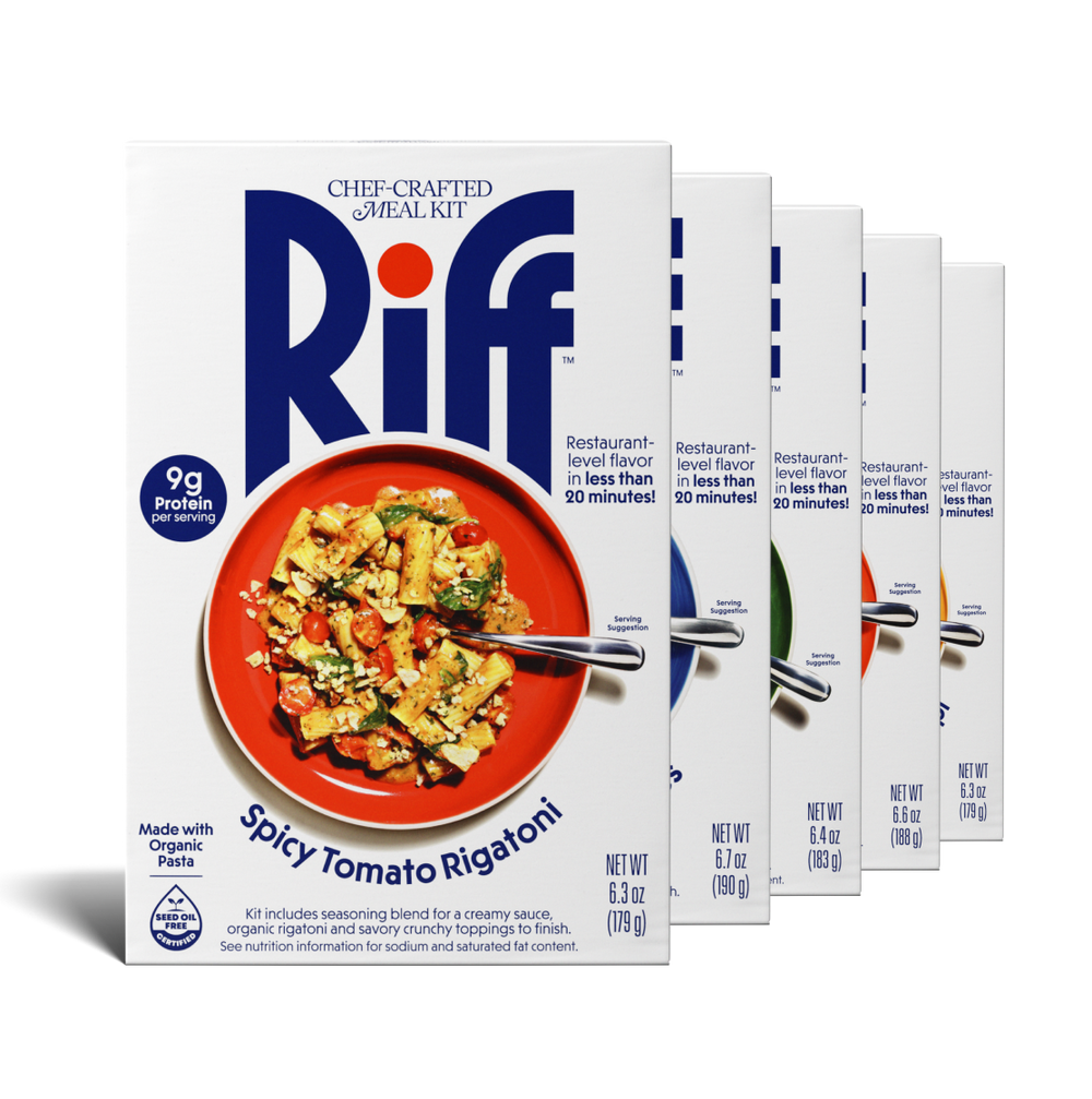 Five Riff chef-crafted meal kit boxes fanned out in a row, with a box of Spicy Tomato Rigatoni in front showing a red plate of pasta and partial views of the other four flavor boxes behind it.