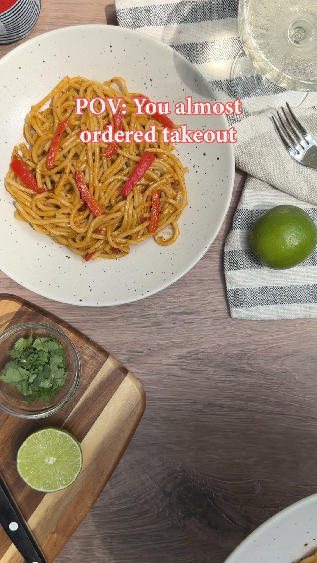 Video of red bell peppers being sliced on a cutting board, followed by an overhead shot of a plate of noodles with red bell pepper strips and the on-screen text "POV: You almost ordered takeout."