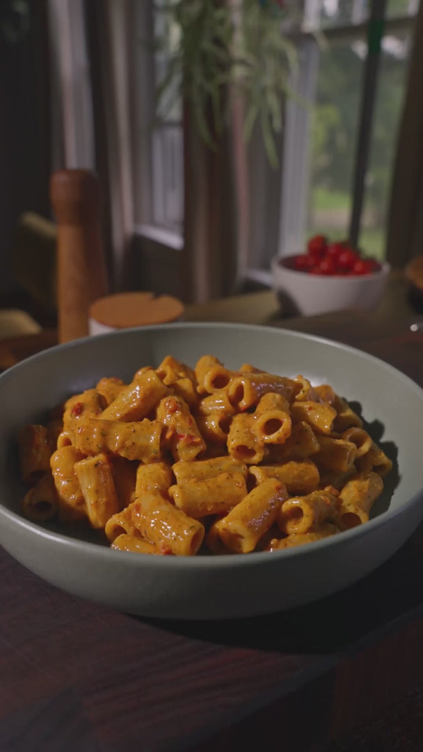 Video of crunchy topping crumbles being sprinkled over a plate of Riff rigatoni pasta in tomato sauce.